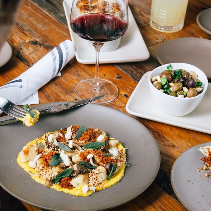 Stone House New American cuisine: a plate of gnocchi with mushrooms, sage, and breadcrumbs, with wine.