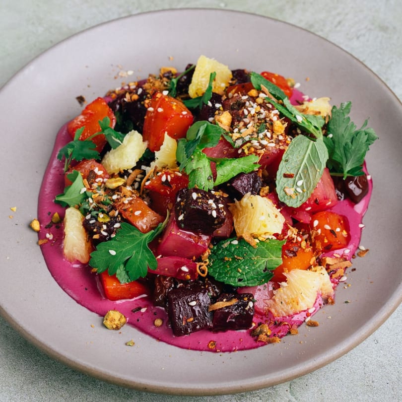 Stone House's vibrant beet salad with grapefruit, herbs, and seeds on a purple puree.